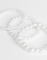Set de tres pulseras elásticas con perlas sintéticas blancas.
