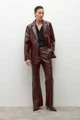 Pantalón de eco cuero color marrón oscuro (chocolate) con textura de cocodrilo (crocco) y corte recto/acampanado.