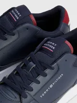 Zapatillas urbanas Tommy Hilfiger color azul marino, con cordones, suela blanca y detalles en rojo. Logo de la marca en el lateral y la lengüeta.