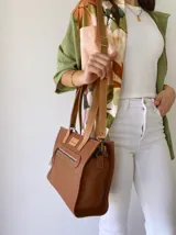 Cartera bandolera de cuero color tostado, con correa larga regulable, bolsillo frontal y forro de tela.