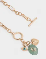 Collar dorado con cadena de eslabones y cierre de aro con barra en la parte delantera. Incluye dijes colgantes: piedra verde ovalada con diseño de hojas, ojo turco y corazón dorado con textura.