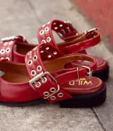 Ballerinas negras de cuero con punta cuadrada, tira sobre el empeine con hebilla metálica y detalle de ojalillos plateados.
