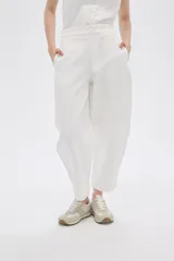 Pantalón blanco de poliéster, corte ancho, tiro alto y bolsillos laterales.