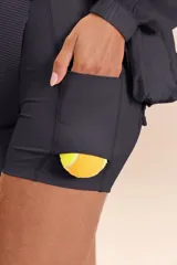 Pollera deportiva color azul marino con diseño plisado, cintura elástica y short interno.