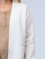 Cardigan color oliva con textura acolchada y bolsillos laterales.