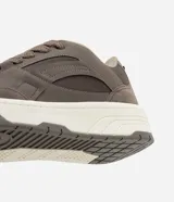 Championes de estilo urbano, color beige claro, con cordones gruesos trenzados y suela ancha de plataforma en tonos crema y gris. Presenta recortes en material sintético liso y gamuzado.