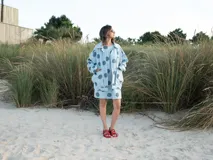 Vestido corto celeste con lunares grandes color azul, sin mangas y corte recto.