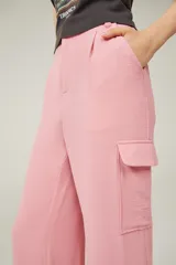 Pantalón de vestir rosa con textura, corte recto, tiro alto y bolsillos cargo laterales.