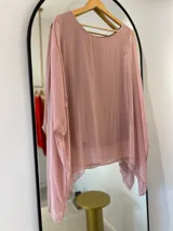 Blusa de seda italiana color rosa pálido, con cuello redondo, corte asimétrico y musculosa integrada.