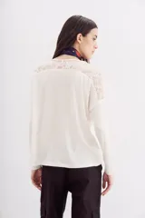 Remera negra de manga larga con detalle de encaje en hombros y espalda.