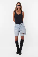 Bermuda de jean celeste con roturas, tiro medio, terminación al corte con pespunte de seguridad, cintura con pasacintos, cartera de cierre y botón metálico personalizado.
