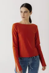 Remera de manga larga color naranja, con escote barco y aberturas en los puños.