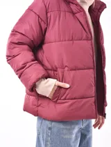 Campera puffer color gris topo, con cuello alto y cierre frontal.