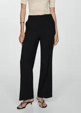Pantalón negro de corte wide leg, tiro medio y tejido fluido.