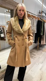 Tapado color camel con cuello de piel sintética color beige, doble botonadura y lazo para ajustar en la cintura.