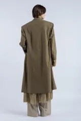 Tapado largo color verde oliva, de corte recto y silueta amplia, con diseño cruzado y cierre frontal de doble botonadura. Presenta solapas clásicas, hombros estructurados y largo por debajo de la rodilla. Confeccionado en lana y algodón.