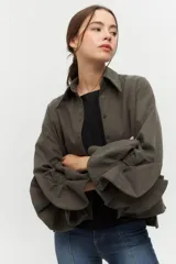 Camisa negra con cuello clásico y mangas largas con detalle de volados en los puños.