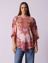 Blusa de gasa estampada con cuello a la base, escote en V y botón. Manga ¾ con terminación amplia y ruedo en pico.