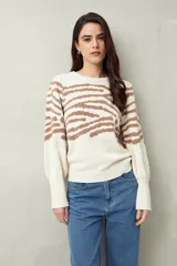 Sweater de punto color crudo con estampado animal print en tonos marrones, de mangas abullonadas y puños elastizados.
