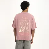 Remera manga corta color marrón con estampado de una flor dorada en el pecho.