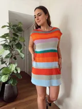 Vestido corto tejido con hilo de algodón en punto jersey rayado. Silueta recta y cuello redondo. Hecho a mano con máquina de carro y terminaciones en crochet.