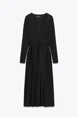 Vestido midi negro de algodón, con escote pico pronunciado, manga larga con puños y detalle de pliegues en el torso. Incluye un cinturón ajustable del mismo tejido anudado a la cintura.