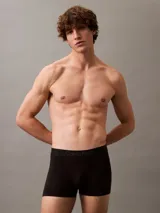 Pack de tres bóxers ajustados Calvin Klein, uno negro, uno gris y uno azul marino, con cintura elástica con logo de la marca.