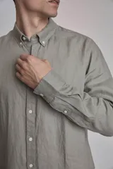 Camisa blanca de lino con cuello abotonado, manga larga con puños abotonados y corte clásico.