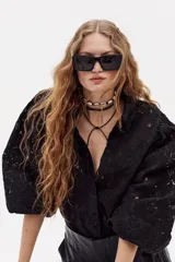 Camisa negra de encaje de algodón con cuello camisero clásico, mangas largas abullonadas con puños elásticos y cierre frontal con botones de nácar.