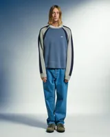 Sweater de tejido de punto con diseño en bloques de color. El cuerpo es azul medio, las mangas son grises con una franja azul marino en la parte superior, y el cuello y puños son acanalados. Presenta un logo bordado pequeño en el pecho.