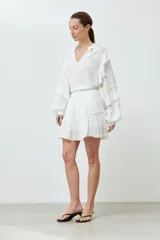 Minifalda blanca de bambula con volados y cintura elastizada.