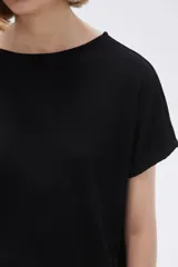 Remera blanca con estampado floral en color lila, de corte holgado y mangas cortas.