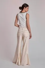 Pantalón de jean color crudo, corte palazzo con godets y costuras a contratono.