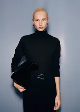 Jersey negro de punto fino con cuello alto, manga larga y terminaciones de canalé.