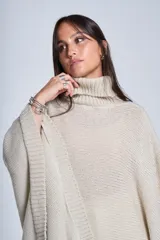 Poncho polerón negro tejido con cuello alto y mangas 3/4.