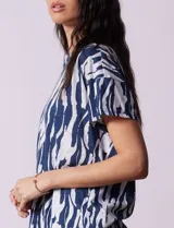 Blusa de algodón con estampado animal print en tonos grises, cuello redondo y manga corta.