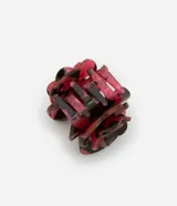 Pinza para el pelo con forma de rosa, de plástico color rojo y negro con estampado jaspeado.