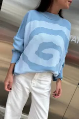 Sweater de punto color rosa con espiral en color fucsia, de cuello redondo y mangas largas.