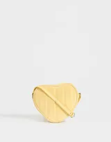 Bandolera negra en forma de corazón, confeccionada en cuerina acolchada con pespuntes verticales. Tiene correa larga regulable y cierre superior.