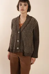 Cárdigan tejido a rayas verticales marrones y beige, con cuello esmoquin, cierre frontal con botones y corte holgado. Tejido en 100% lana fina sin teñir.