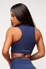 Top deportivo azul marino con cuello polo y cierre parcial con cremallera.