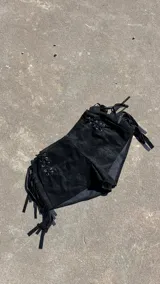 Short negro de gamuza con cordones cruzados en los laterales y flecos.