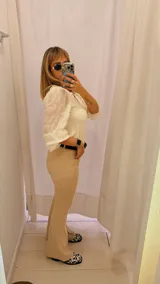 Pantalón de vestir color beige, de tiro alto, corte recto y terminación acampanada.