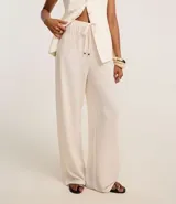 Pantalón wide leg color beige con textura, cintura elástica con cordón ajustable y bolsillos laterales.