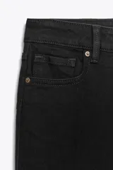 Pantalón de jean negro de tiro bajo, corte slim fit y bootcut. Tiene cinco bolsillos y cierre frontal con cremallera y botón.