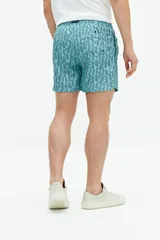 Short de baño turquesa con estampado abstracto en blanco, cintura elástica con cordón ajustable, dos bolsillos laterales y uno trasero.