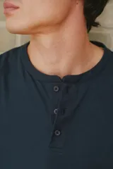 Remera azul marino de manga corta con cuello henley de tres botones.