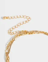 Collar doble con cadenas doradas de diferentes diseños. La cadena más corta tiene dijes de cerezas con strass rojos y verdes. Cierre de mosquetón.