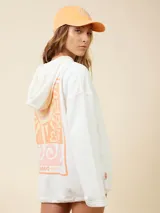 Canguro cropped color crema con capucha y cordón ajustable en la cintura. Estampado de un sol en el pecho.