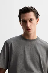 Camiseta gris de corte recto, cuello redondo y manga corta.